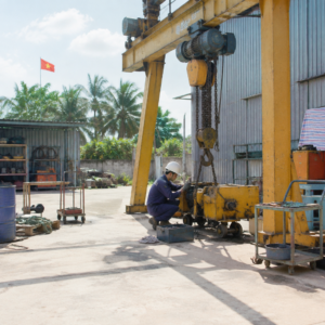 Kỹ thuật viên đang kiểm tra một phần của thiết bị nâng hạ công nghiệp để tìm sự cố